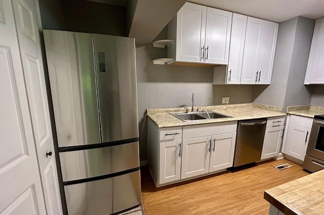 297 Anderson St, Crestview, FL 32536 - kitchen featuring stainless steel appliances, a sink, open shelves, light wood finished floors, and light countertops