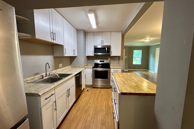 297 Anderson St, Crestview, FL 32536 - kitchen with wood counters, appliances with stainless steel finishes, light wood-style floors, and a sink
