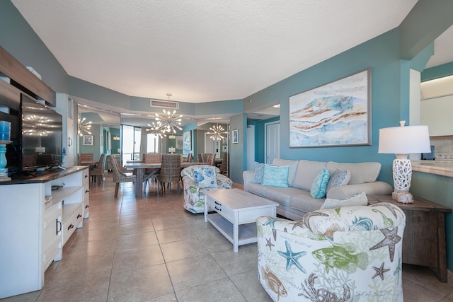 living room with visible vents, a textured ceiling, light tile patterned flooring, and a chandelier