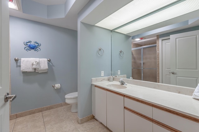 bathroom with a shower stall, vanity, baseboards, tile patterned floors, and toilet