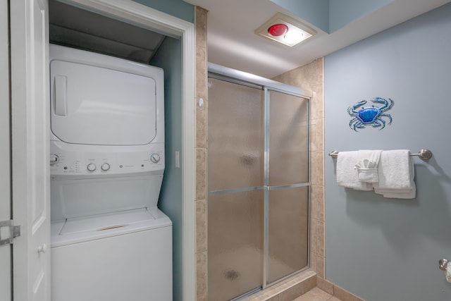 bathroom featuring a shower stall and stacked washer and dryer