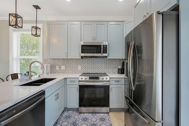 kitchen with sink, hanging light fixtures, stainless steel appliances, gray cabinets, and crown molding