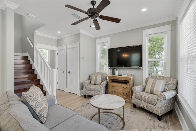 living room with crown molding, light wood-type flooring, and ceiling fan