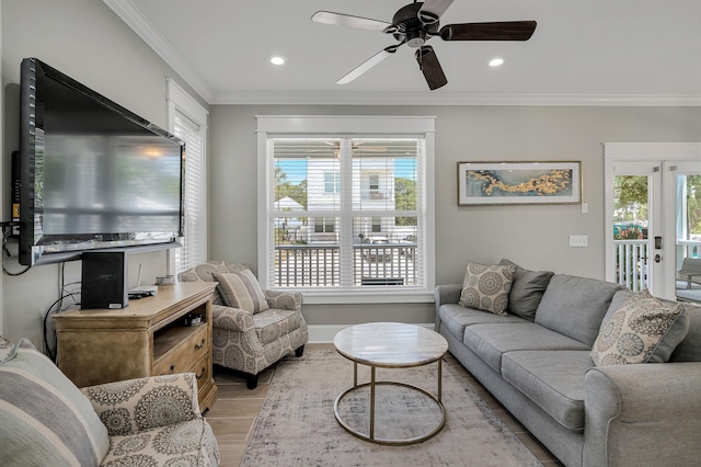 living room with ornamental molding, light hardwood / wood-style floors, and ceiling fan