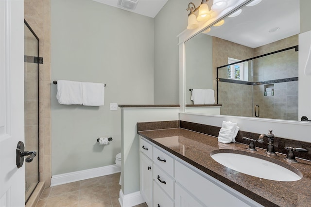 bathroom featuring toilet, walk in shower, vanity, and tile patterned flooring