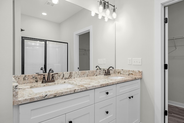 bathroom with vanity, hardwood / wood-style flooring, and a shower with door