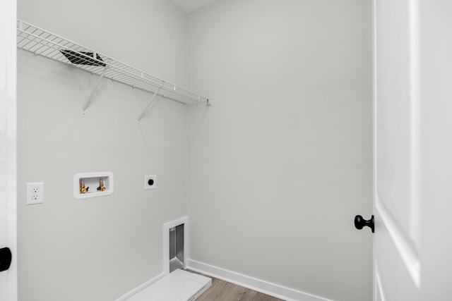 clothes washing area featuring wood-type flooring, washer hookup, and hookup for an electric dryer