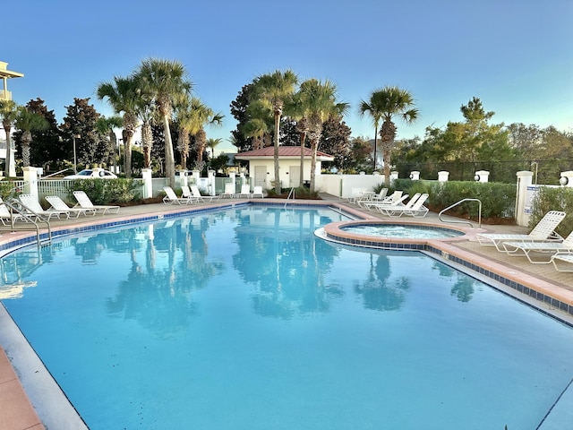 view of pool with a hot tub and a patio area