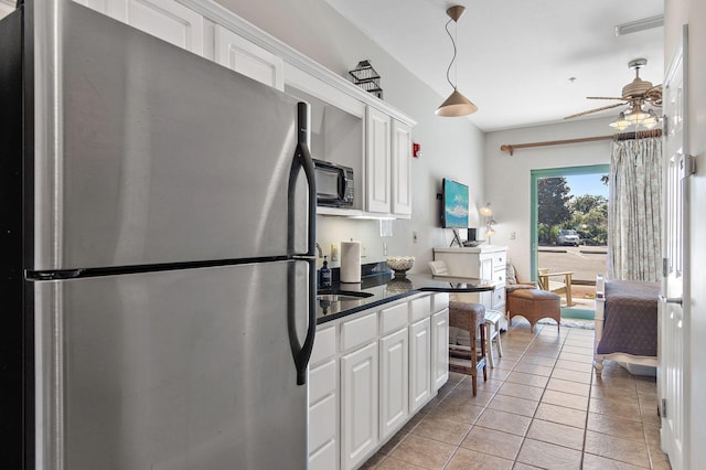 kitchen with white cabinets, ceiling fan, stainless steel refrigerator, light tile patterned flooring, and pendant lighting