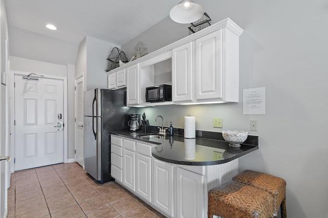 kitchen with sink, white cabinetry, stainless steel refrigerator, and light tile patterned floors