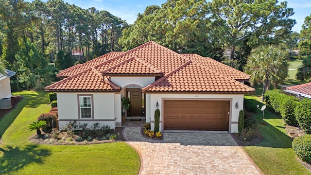 mediterranean / spanish house with cooling unit, a front lawn, and a garage