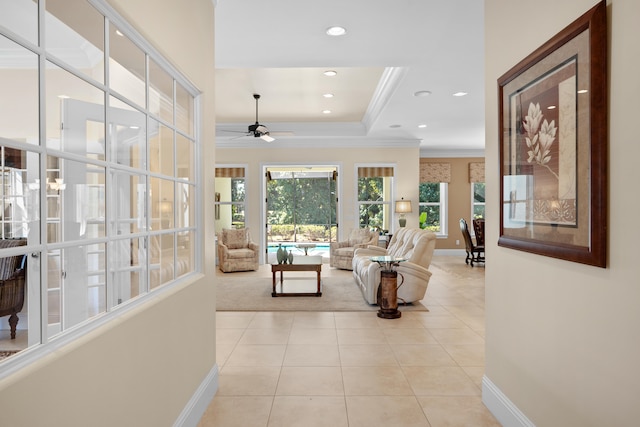 interior space with crown molding, a raised ceiling, and light tile patterned flooring