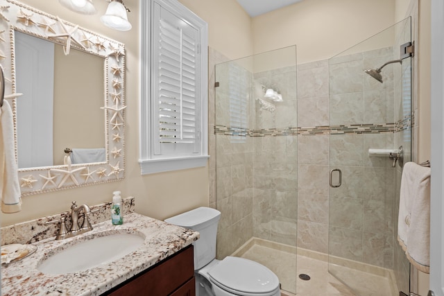 bathroom featuring vanity, an enclosed shower, and toilet