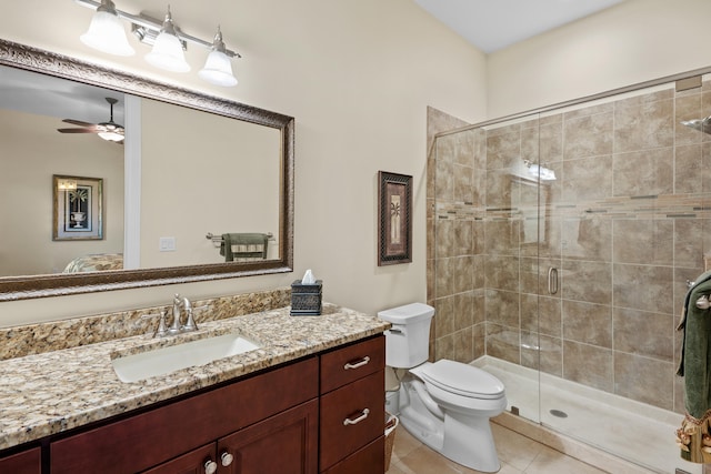 bathroom with a shower with door, tile patterned floors, toilet, vanity, and ceiling fan