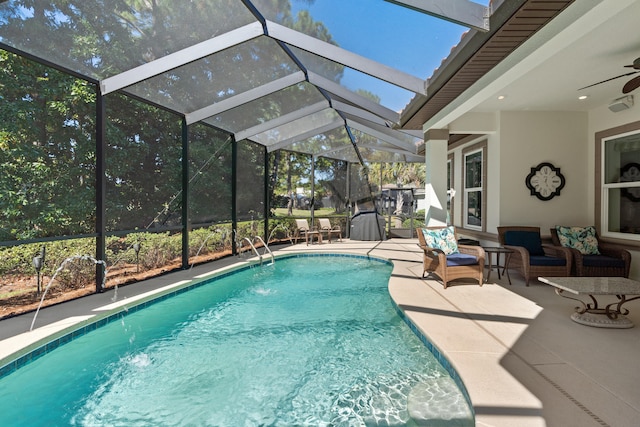 view of pool featuring a patio area, a lanai, ceiling fan, pool water feature, and outdoor lounge area