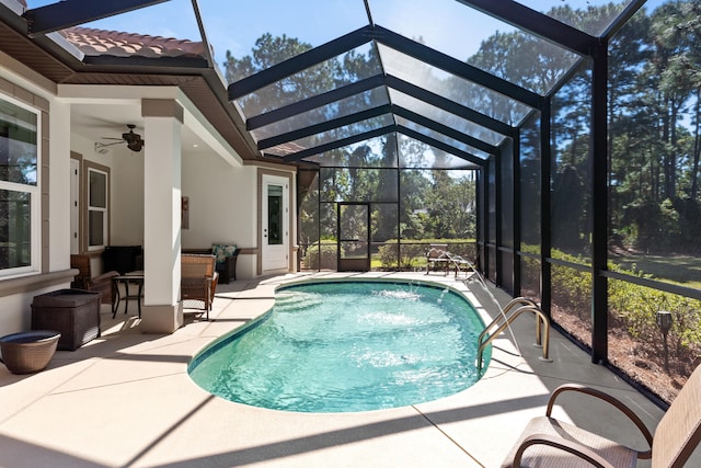 view of swimming pool featuring ceiling fan, glass enclosure, and a patio area