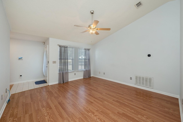 spare room featuring light hardwood / wood-style floors, ceiling fan, a textured ceiling, and vaulted ceiling