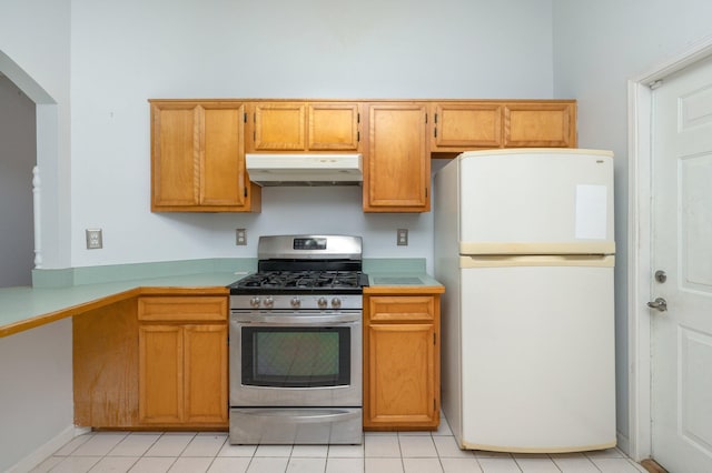 9 Holly Rd, Crestview, FL 32539 - kitchen with brown cabinetry, freestanding refrigerator, under cabinet range hood, light countertops, and stainless steel gas range