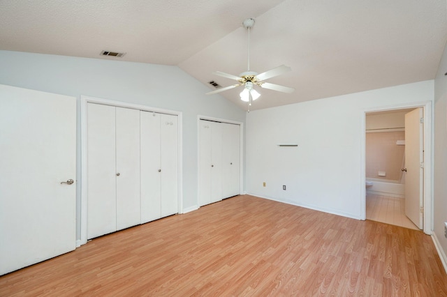 9 Holly Rd, Crestview, FL 32539 - unfurnished bedroom with vaulted ceiling, multiple closets, light wood-style flooring, and visible vents