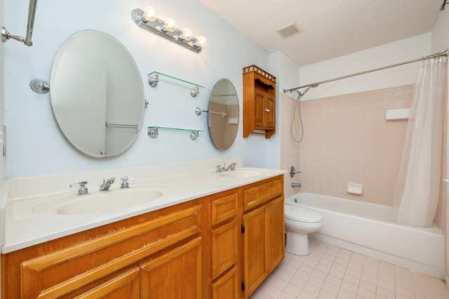 full bathroom featuring tile patterned flooring, a textured ceiling, shower / tub combo with curtain, vanity, and toilet