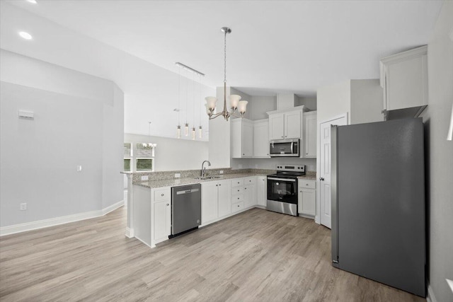 kitchen featuring white cabinets, light wood-type flooring, stainless steel appliances, sink, and decorative light fixtures