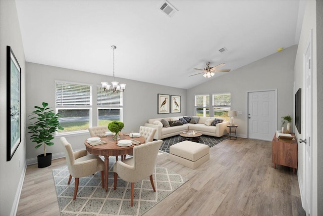 dining room featuring lofted ceiling, ceiling fan with notable chandelier, and light hardwood / wood-style floors