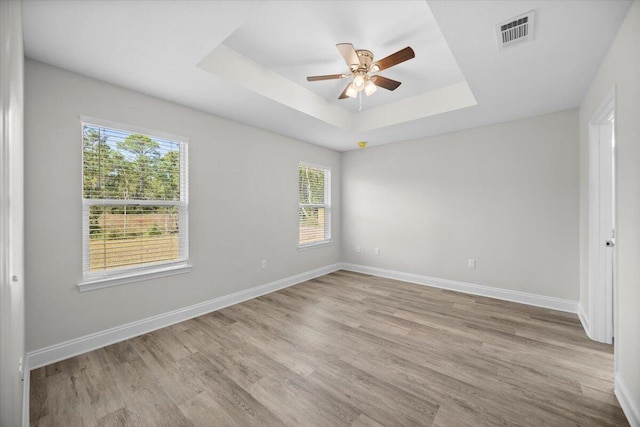 unfurnished room with light wood-type flooring, a healthy amount of sunlight, and ceiling fan