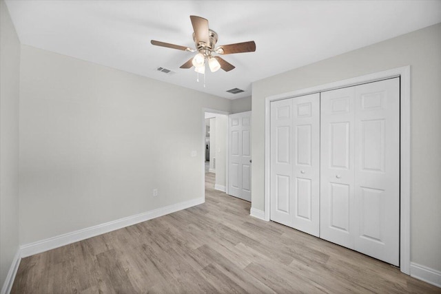 unfurnished bedroom with light hardwood / wood-style floors, a closet, and ceiling fan