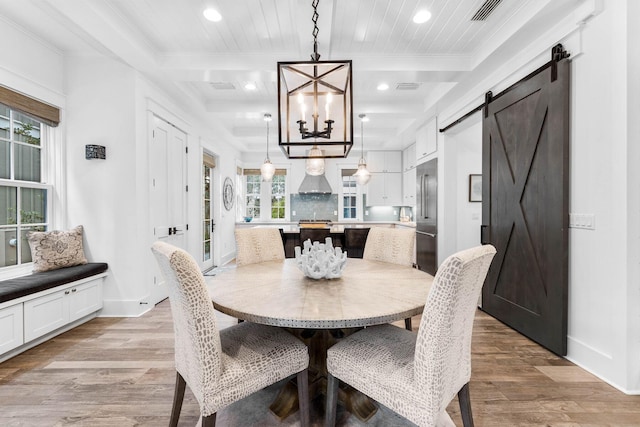 79 Cedar Post Rd, Santa Rosa Beach, FL 32459 - dining space featuring a barn door, an inviting chandelier, light hardwood / wood-style flooring, and ornamental molding