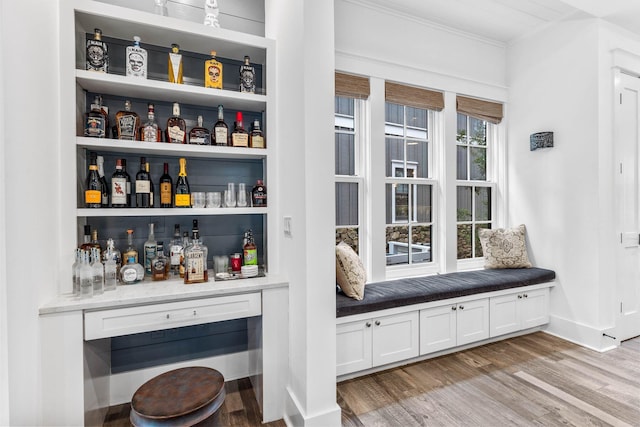 79 Cedar Post Rd, Santa Rosa Beach, FL 32459 - bar with light stone countertops, white cabinetry, light hardwood / wood-style flooring, and ornamental molding