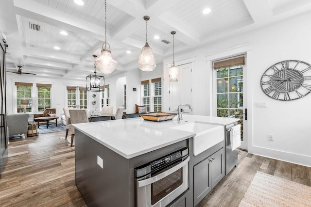 79 Cedar Post Rd, Santa Rosa Beach, FL 32459 - kitchen featuring light wood-type flooring, gray cabinetry, stainless steel appliances, pendant lighting, and a center island with sink