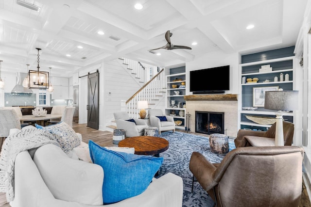 living room with beamed ceiling, hardwood / wood-style floors, a barn door, and coffered ceiling