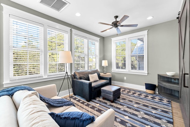 79 Cedar Post Rd, Santa Rosa Beach, FL 32459 - living room with a barn door, ceiling fan, and a healthy amount of sunlight