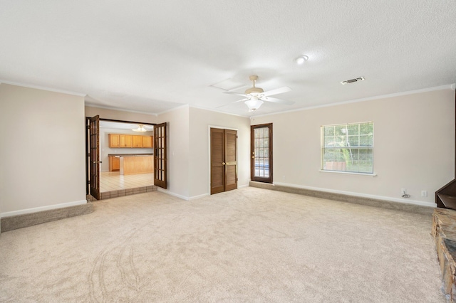 empty room with crown molding, light carpet, a textured ceiling, and ceiling fan