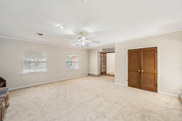 interior space featuring light carpet, crown molding, a textured ceiling, and ceiling fan