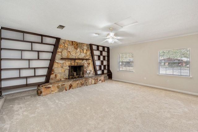 unfurnished living room with light carpet, a stone fireplace, a textured ceiling, and crown molding