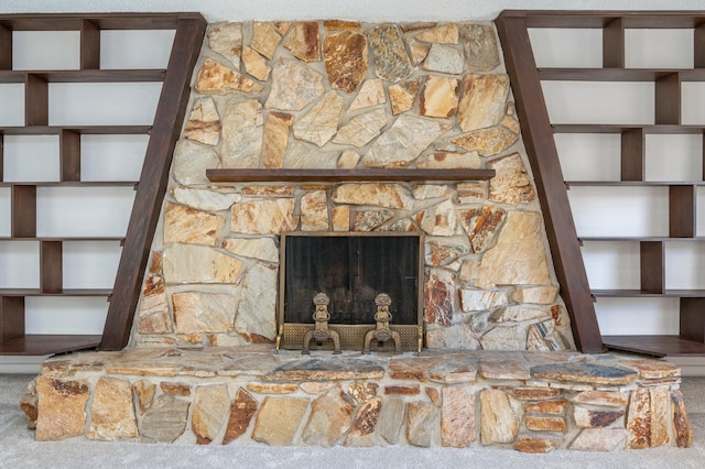 interior details with a stone fireplace and carpet floors