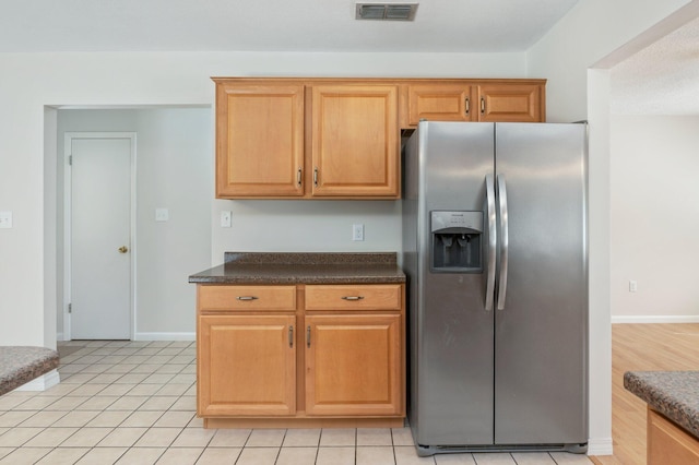 kitchen featuring stainless steel fridge and light tile patterned flooring