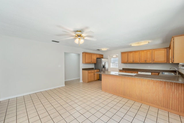 kitchen with kitchen peninsula, white dishwasher, sink, stainless steel fridge, and ceiling fan