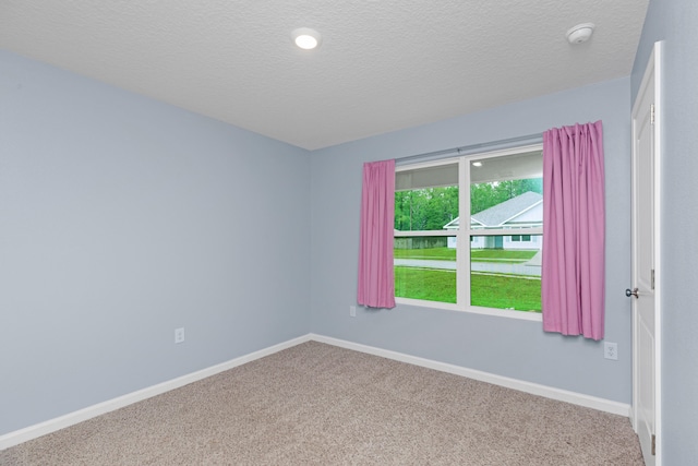 carpeted empty room with a textured ceiling