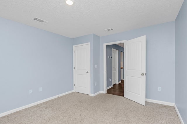 unfurnished bedroom with a textured ceiling and carpet flooring