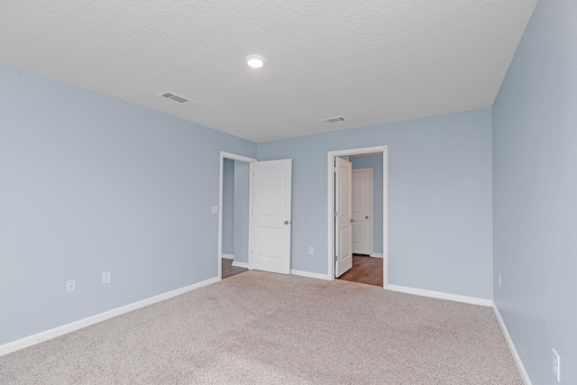 unfurnished bedroom featuring a textured ceiling and carpet floors