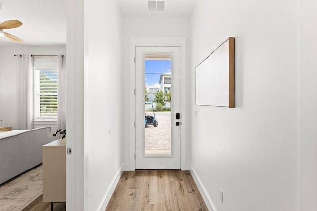 doorway to outside featuring ceiling fan and light hardwood / wood-style flooring