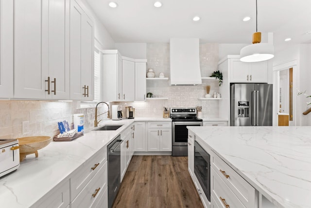 kitchen featuring stainless steel appliances, hanging light fixtures, white cabinets, and sink