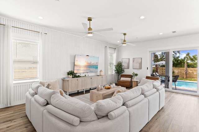 living room featuring light hardwood / wood-style flooring and ceiling fan