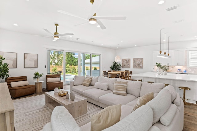 living room featuring light hardwood / wood-style flooring and ceiling fan