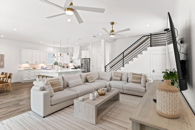 living room with light hardwood / wood-style flooring and ceiling fan