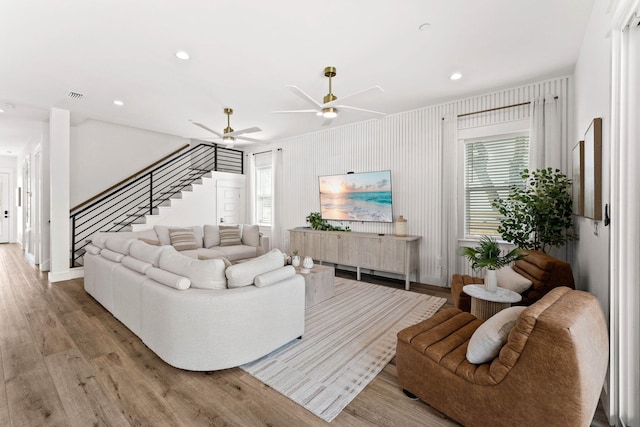 living room featuring light hardwood / wood-style flooring and ceiling fan