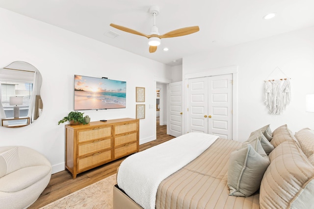 bedroom with a closet, light wood-type flooring, and ceiling fan