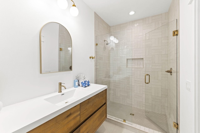 bathroom featuring a shower with shower door, vanity, and tile patterned floors